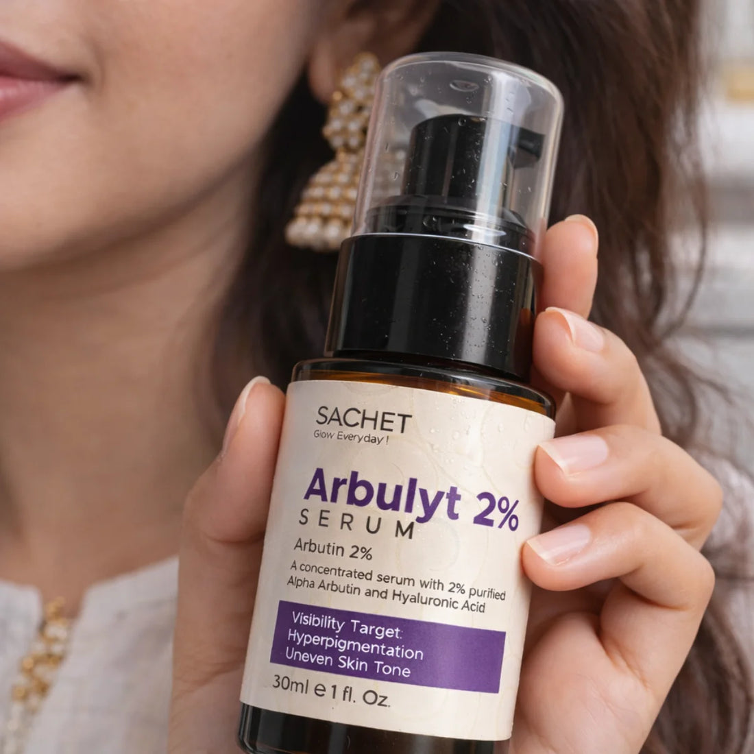 Person holding a bottle of SACHET Arbulyt 2% Serum
