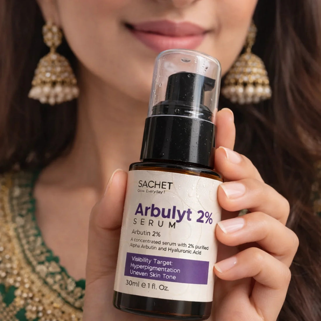 Woman holding a bottle of SACHET Arbulyt 2% Serum with a blurred background