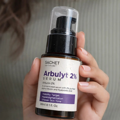 Hand holding a bottle of Arbulyt 2% Serum by SACHET against a neutral background