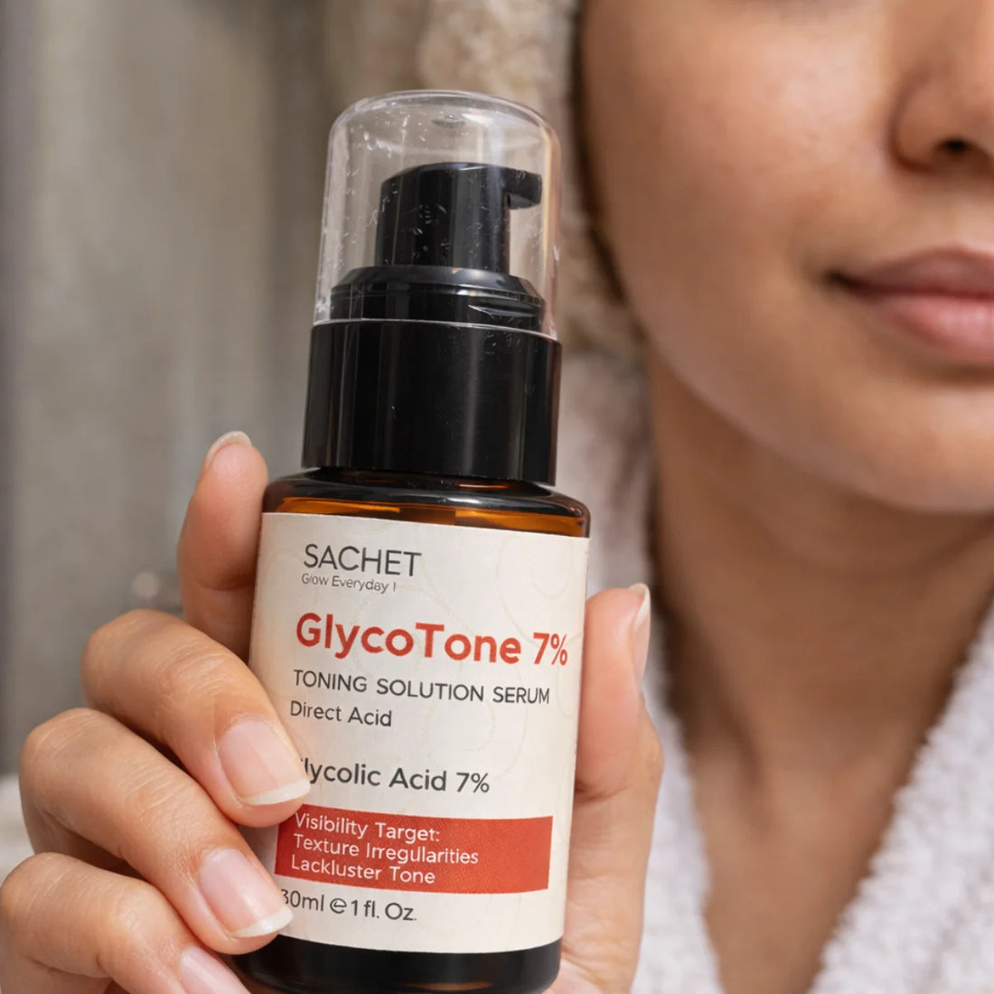 Person holding a bottle of Sachet GlycoTone 7% toning solution serum close to their face.