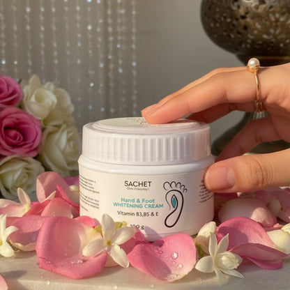 Person holding a container of 'Sachet' hand and foot whitening cream with promotional text on a green background.